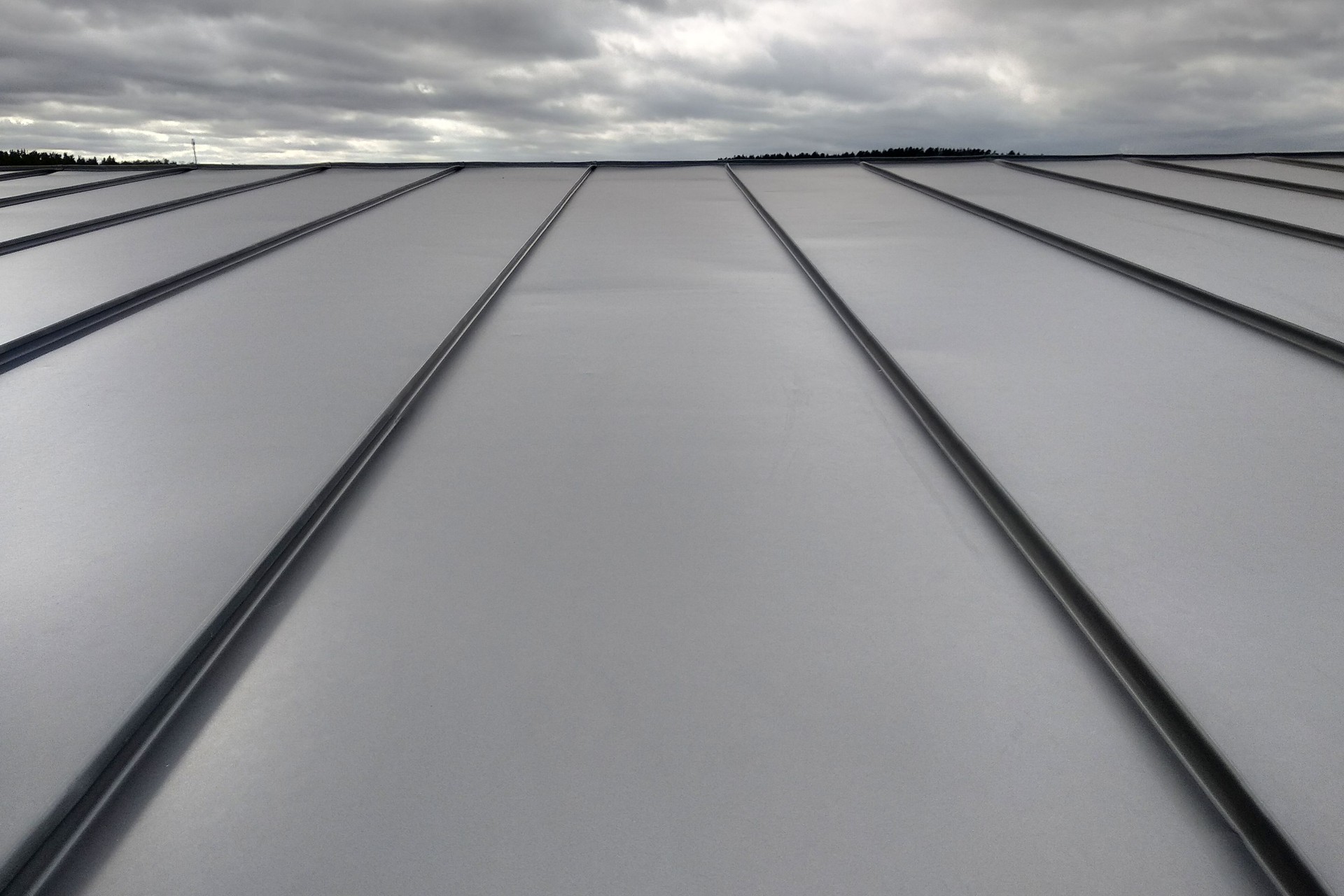 Close-up detail of house roof made from gray metal sheets.